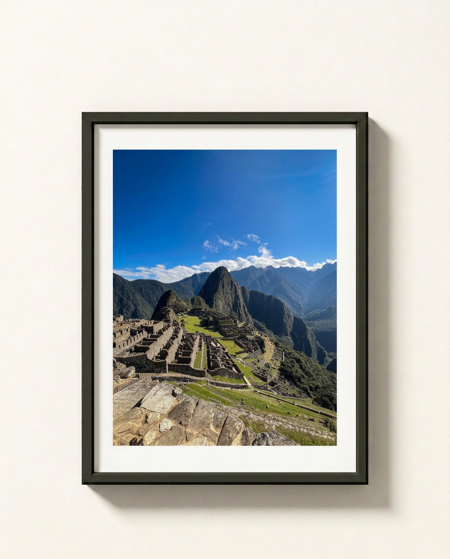 A framed photographic print of the ancient ruins of Machu Picchu under a bright blue sky, displayed on a light beige wall.